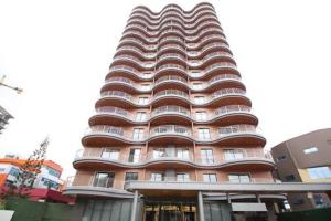 a tall red building with aavy at Intimate Studio Apartment - Mirage Residence in Accra