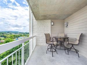 un patio avec une table et des chaises sur un balcon dans l'établissement Smoky Mountain Memories Whispering Pines 232, à Pigeon Forge