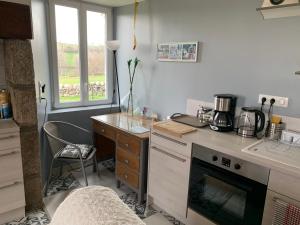 cocina con encimera, mesa y silla en Fontanies en Aubrac en Laguiole