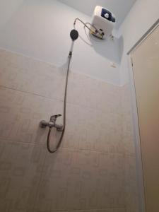 a shower in a bathroom with a shower head at Guguak Puro Guest House in Padangpanjang