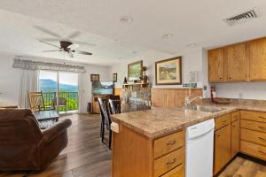 a kitchen with a sink and a living room at Deer Ridge Mountain Resort E208 in Gatlinburg