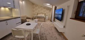 a kitchen and a living room with a table and chairs at Carice Milice Old Town Residence in Belgrade