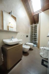 a bathroom with a sink and a toilet and a mirror at [DUOMO] Elegant Penthouse in Parma
