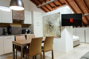 a kitchen and dining room with a table and chairs at [DUOMO] Elegant Penthouse in Parma