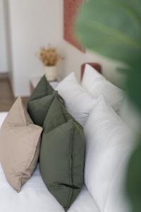 un grupo de almohadas en una cama blanca en TH-Homes scandinavia interior 1 BR at Wasl 1 en Dubái
