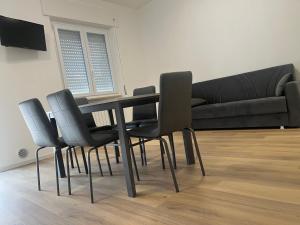 a dining room table with black chairs and a couch at La casa dello zio in Vasto