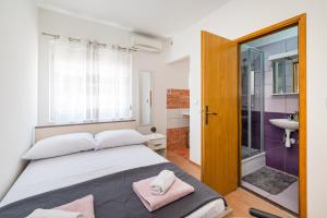 a bedroom with a bed and a bathroom with a sink at Studio and Rooms Zadar City Wall in Zadar