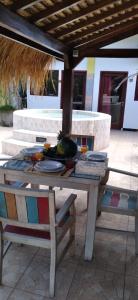 a table with a bowl of fruit and a chair at Villa Cinta Family in Gili Trawangan