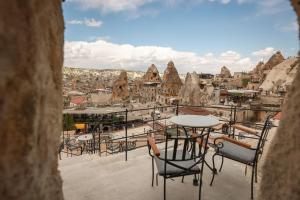 a balcony with tables and chairs and a view of a city at Mia Cappadocia Cave Hotel in Goreme