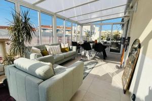 - un salon avec des canapés, une table et des fenêtres dans l'établissement Rooftop Garden, à Antibes