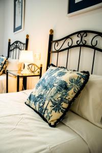 Una cama con una almohada azul y blanca. en Escuela Village, en Marbella