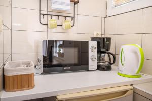 a kitchen counter with a microwave and a coffee maker at Studio and Rooms Zadar City Wall in Zadar