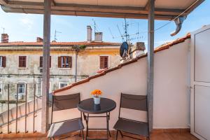 einen Tisch und Stühle auf einem Balkon mit Aussicht in der Unterkunft Studio and Rooms Zadar City Wall in Zadar