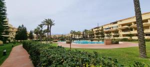 een resort met een zwembad en een gebouw bij Apartamento LUXURY en ROQUETAS DE MAR - PLAYA SERENA Urbanización VILLA ROMANA in Roquetas de Mar