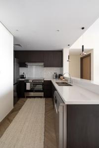 a kitchen with a white counter and a sink at TH-Homes scandinavia interior 1 BR at Wasl 1 in Dubai