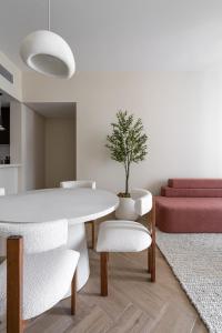 TH-Homes scandinavia interior 1 BR at Wasl 1 في دبي: غرفة معيشة مع طاولة وكراسي بيضاء