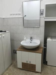 a bathroom with a sink and a mirror at Szenes-House Apartman in Budapest