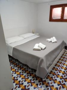 a large bed with two towels on top of it at Villa Rita Apartment in Fontane Bianche