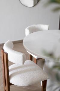 une table blanche et une chaise blanche à côté d'une table dans l'établissement TH-Homes scandinavia interior 1 BR at Wasl 1, à Dubaï