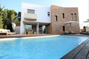 a swimming pool in front of a house at Modern Villa Montecristo in Montecristo