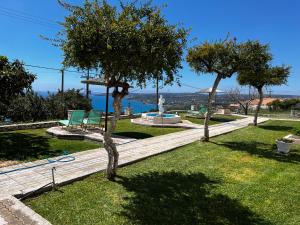 un jardin avec deux arbres, un banc et une fontaine dans l'établissement Ocean Front Studios 77, à Lourdhata