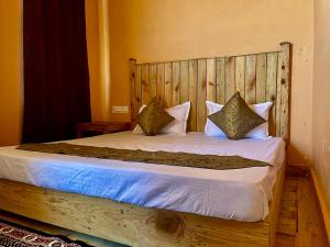 帕拉姆普爾的住宿－Aalna by Ecostel，一张带木制床头板和枕头的床