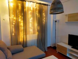 salon z kanapą i zasłoną z oświetleniem w obiekcie Rincón de luz w mieście Linares