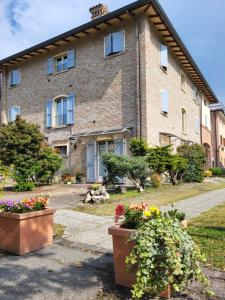 ein großes Backsteingebäude mit zwei Topfpflanzen davor in der Unterkunft Residence Antico Borgo in Modena