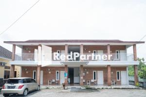 日惹House Acasia Syariah near Universitas Aisyiah Yogyakarta Mitra RedDoorz的一栋建筑前停着一辆车