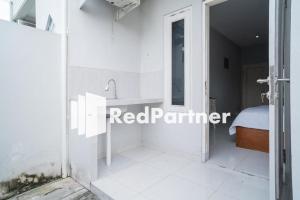 日惹House Acasia Syariah near Universitas Aisyiah Yogyakarta Mitra RedDoorz的带淋浴和水槽的白色浴室