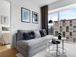 a living room with a couch and a window at Sanders Arena - Chic Three-Bedroom Apartment Close to Metro Station in Copenhagen