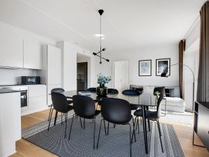 a kitchen and dining room with a table and chairs at Sanders Arena - Chic Three-Bedroom Apartment Close to Metro Station in Copenhagen