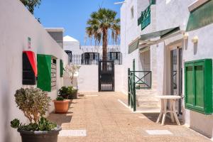 a street with white buildings and palm trees at Suite princesa teguise vista al mar in Puerto del Carmen