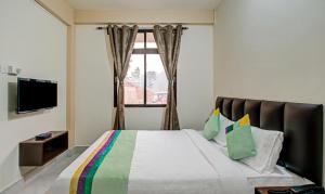 a bedroom with a large bed with a window at Treebo Trend Staying Center in Shillong