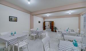 a dining room with white tables and white chairs at Treebo Trend Staying Center in Shillong