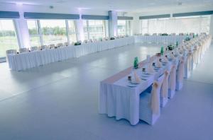 un salón de banquetes con mesas blancas y sillas blancas en KIRÁLY PARK HOTEL, en Szombathely