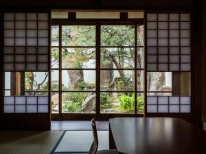 Nipponia Izumo Hirata Cotton Road في إزومو: غرفة مع طاولة و نافذة كبيرة