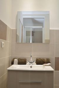 La salle de bains est pourvue d'un lavabo et d'un miroir. dans l'établissement Hotel Le Terminus, au Lavandou