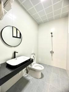 uma casa de banho com um lavatório, um WC e um espelho. em Mỡ Villa Cao Bằng em Cao Bang
