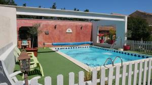 una piscina en un patio con una valla blanca en Mas Maurane - L'Olivier avec SPA privé aux portes d'ARLES en Tarascon