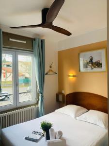 1 dormitorio con 1 cama y ventilador de techo en Hotel Bistrot FINE, en Anglet