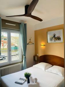 a bedroom with a bed and a ceiling fan at Hotel Bistrot FINE in Anglet +24 photos