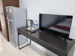 una mesa negra con TV y nevera en Tiara Place en Bangkok