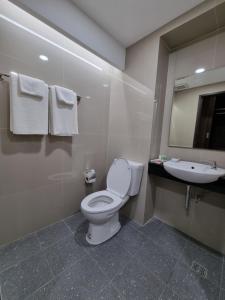 een badkamer met een toilet, een wastafel en een spiegel bij Tiara Place in Bangkok