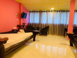 a room with a bed and chairs and a television at Yala Bay Holiday Resort in Tissamaharama