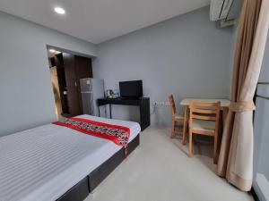 um pequeno quarto com uma cama, uma mesa e cadeiras em Tiara Place em Banguecoque