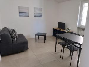 een woonkamer met een bank en een tafel bij Le dimore di San Gervasio in Capriate San Gervasio