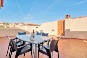 une table bleue et des chaises sur une terrasse avec un toit dans l'établissement Casa Mario, à Puerto Marino