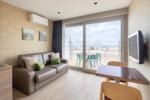 a living room with a couch and a table at C-Hotels Excelsior in Middelkerke