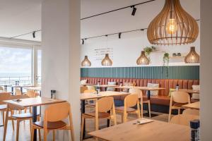 a dining room with wooden tables and chairs at C-Hotels Excelsior in Middelkerke